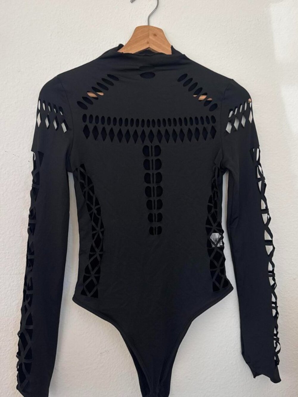 Black polyester & elastane laser cut bodysuit with cut-out geometric design,